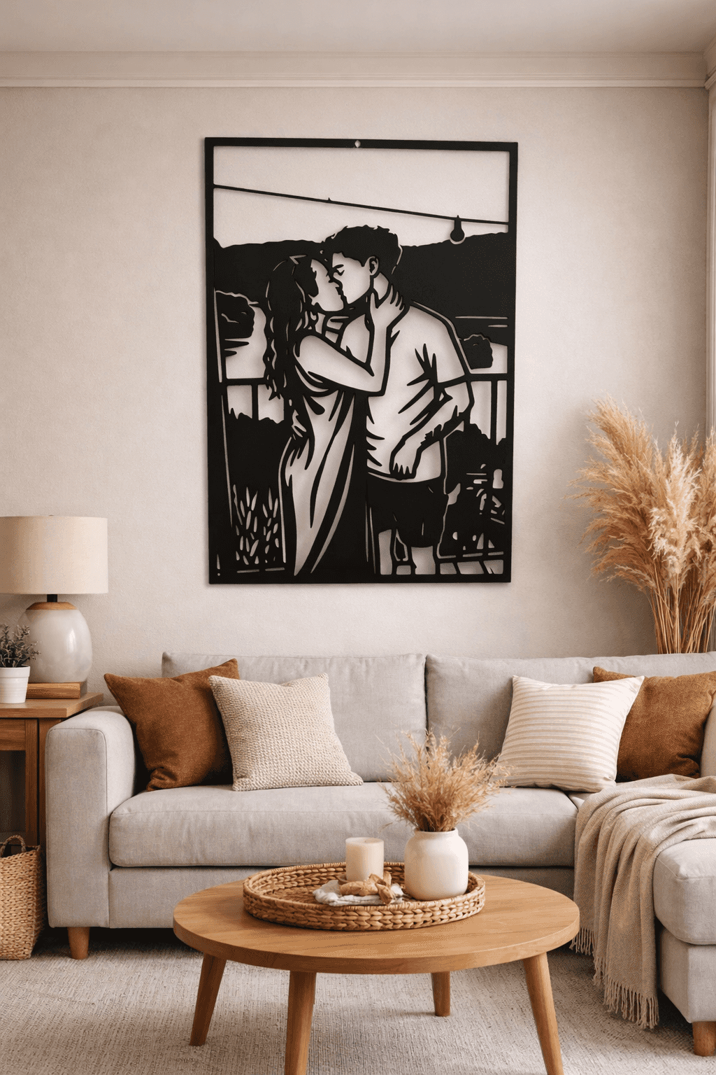 Silhouette en acier noir d’un couple qui s’embrasse sur une terrasse, accrochée au-dessus d’un canapé.